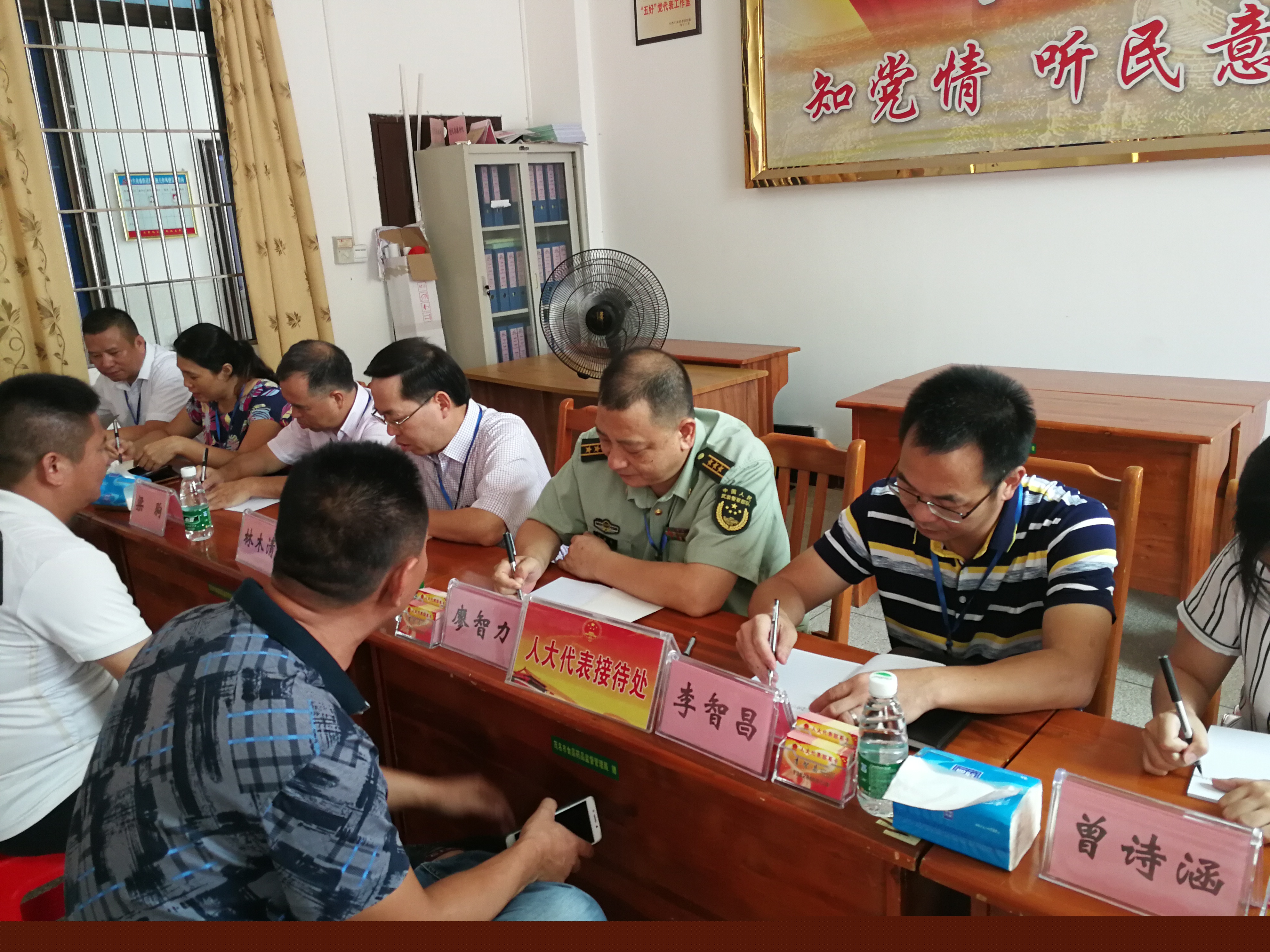 人大代表认真记录群众反映的事项